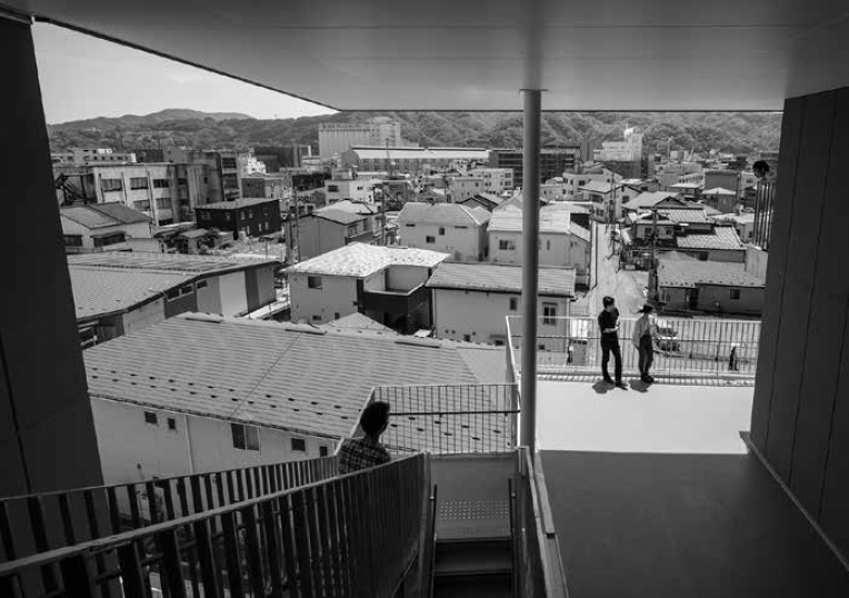 「釜石市天神復興住宅」５階エレベータ前から南側を見る。（写真提供：新建築社）