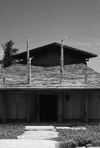 「神長宮守矢史料館」入口。軒を支える柱が屋根を貫く。屋根は地1産の鉄平石葺き